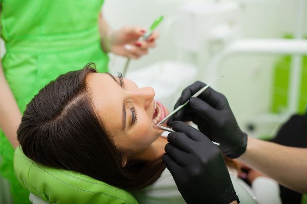 El dentista trata los dientes al cliente en el consultorio dental _ Foto Premium